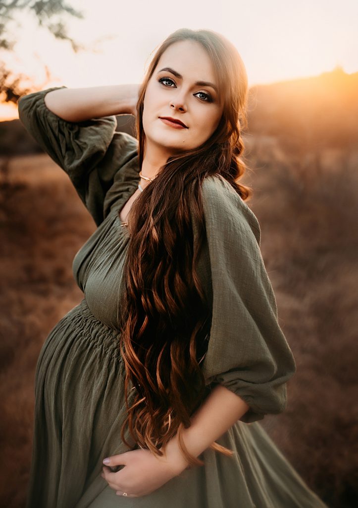 A pregnant mom wearing a green Reclamation dress, by Jessica Rockowitz Photography